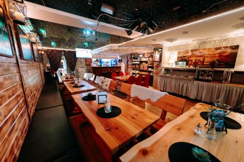 a restaurant with long wooden tables and chairs at ZAJAZD ALBATROS Rzeszow in Rzeszów