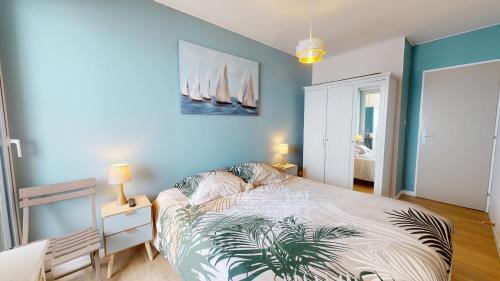 a bedroom with a bed and a blue wall at Panoramic View face Mer in Saint-Gilles-Croix-de-Vie