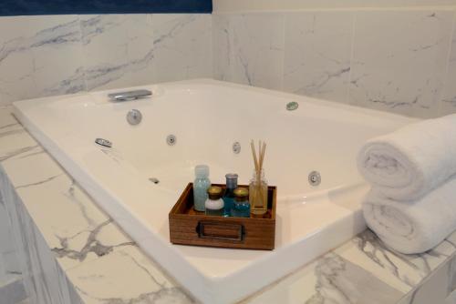 een badkamer met een ligbad en een houten dienblad bij Hotel Casa 20 in León