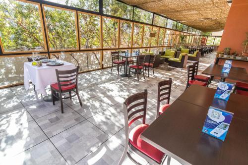 a restaurant with tables and chairs and windows at Geotel Calama in Calama