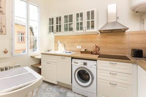 uma cozinha com uma máquina de lavar roupa e um lavatório em Typical 18th century flat, historical center em Avignon