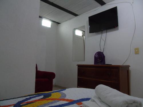 a bedroom with a bed and a tv on the wall at Europa Ecotours in Jardin