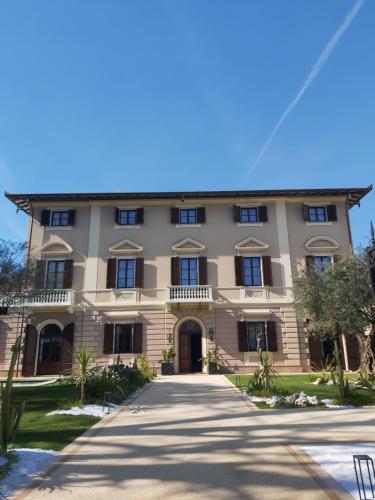 a large building with a driveway in front of it at Resort Al Forte in Forte dei Marmi
