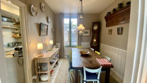 une cuisine avec une table et des chaises dans une pièce dans l'établissement La Villa Médicis, maison familiale pour 6 personnes, au Crotoy