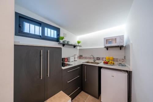 una cocina con armarios de color marrón oscuro y fregadero en OLD TOWN - Cozy Apartment, en Málaga