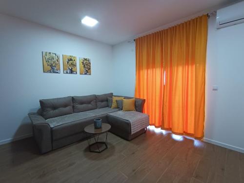 a living room with a couch and an orange curtain at Leon in Kragujevac