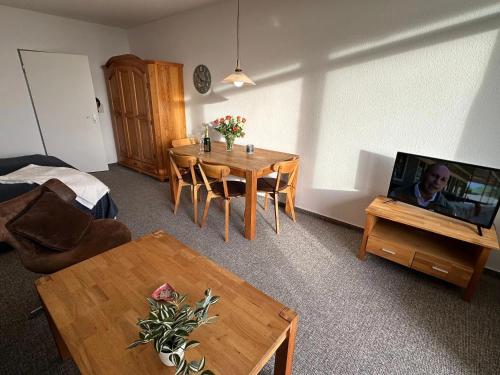 a living room with a table and a flat screen tv at Haubentaucher in Fehmarn