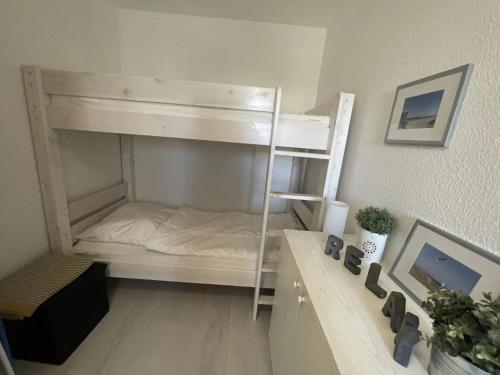 a white bunk bed in a room with a desk at Südstrand Perle in Burgtiefe auf Fehmarn 