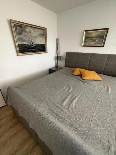 a bedroom with a bed and two pictures on the wall at Meerglück in Burgtiefe auf Fehmarn 