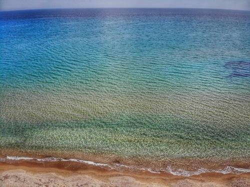 an aerial view of the ocean with the sand and water at Goldfish Seaside Luxury Houses in Kómi