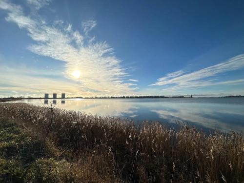 une grande étendue d'eau avec le soleil dans le ciel dans l'établissement Strandläufer, à Burgtiefe auf Fehmarn 