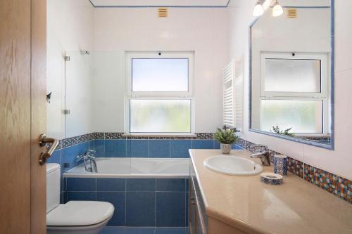 uma casa de banho com uma banheira, um WC e um lavatório. em Vivenda Quinta da Balaia nos Olhos de Água