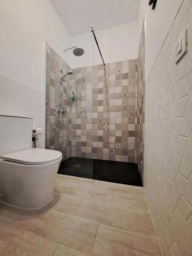 a bathroom with a shower with a tub and a toilet at Sirena Iris in El Cotillo