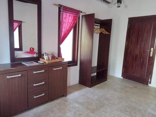 a bathroom with a vanity with a mirror and a window at Gili Air Santay Bungalows in Gili Air