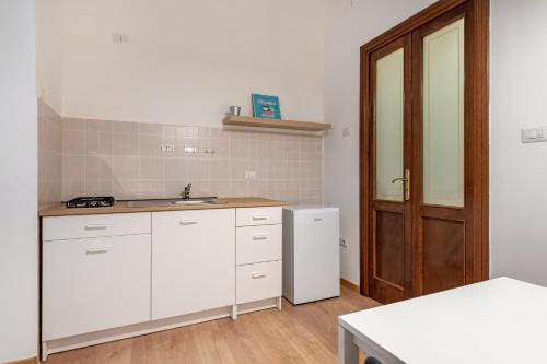 uma cozinha branca com um lavatório e um frigorífico em Manzoni Apartment em Bari