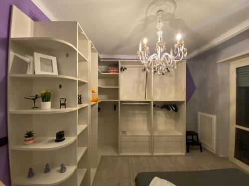 Cette chambre est dotée d'étagères blanches et d'un lustre. dans l'établissement Manhattan House, à Turin