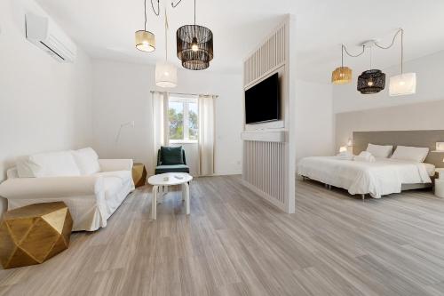 a white bedroom with two beds and a tv at Soltroia Beach Court -Heated Pool in Troia