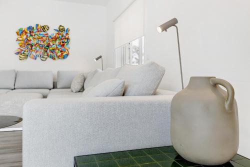 a white living room with a white couch and a vase at Soltroia Beach Court -Heated Pool in Troia