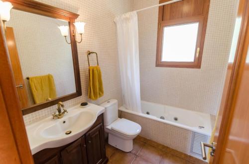 een badkamer met een wastafel, een toilet en een raam bij Club Villamar - Ayarza in Maçanet de la Selva