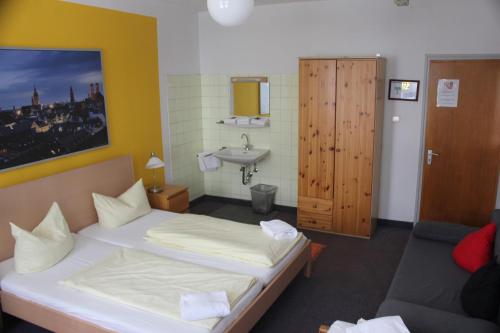 a small room with a bed and a sink at Hotel Pension am Hauptbahnhof in Munich