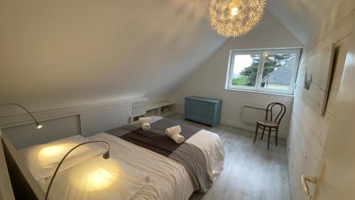 une chambre avec un lit et un lustre dans l'établissement Cottage de la mer, au Crotoy