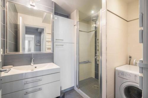 a bathroom with a sink and a washing machine at La mer à vos pieds, la plage à 50m in Dinard