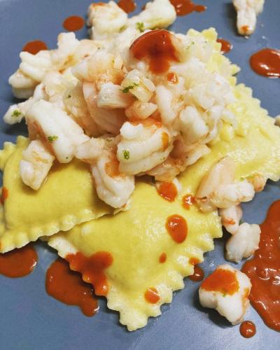 a plate of food with shrimp on a piece of cheese at La Corte Nascosta Volpedo in Volpedo