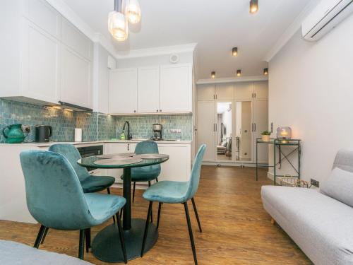 a kitchen with a table and chairs in a room at Flatbook - City Center Apartments Granaria II in Gdańsk