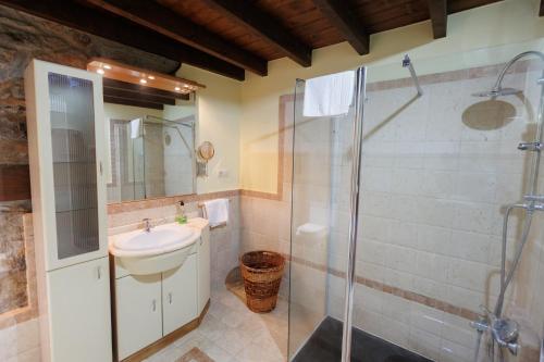 La salle de bains est pourvue d'une douche en verre et d'un lavabo. dans l'établissement Hotel Rural El Molino, à Soto de Cangas