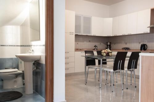 a kitchen with white cabinets and a black table and chairs at Naelia in Pastida