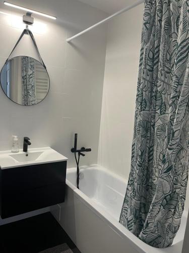 a bathroom with a sink and a shower curtain at Cosy Apartment-Marine in Rumia