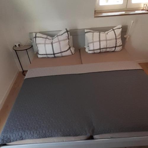 uma cama num quarto com duas almofadas em Blickpunkt em Feucht