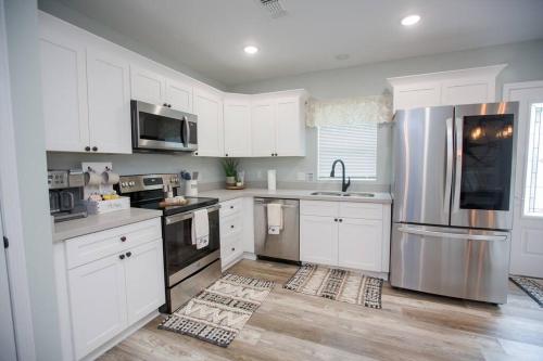 a kitchen with white cabinets and a stainless steel refrigerator at Captain's Cove in Long Beach