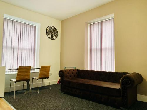 a living room with a couch and two chairs at Marina Apartments in Bradford