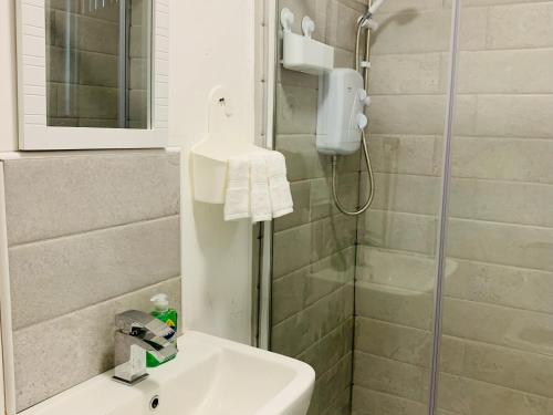 uma casa de banho com um lavatório e um chuveiro em Marina Apartments em Bradford