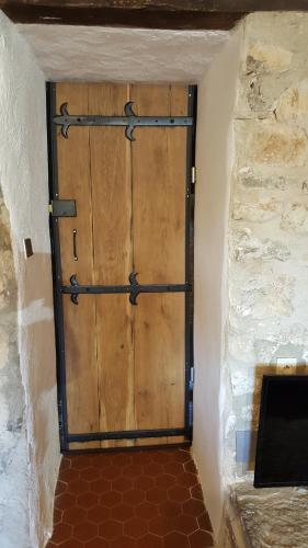 - une grande porte en bois dans une chambre dotée d'un mur en briques dans l'établissement mas de la berlusiere, à Saint-André-de-Cruzières