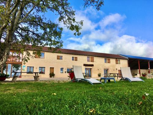 un groupe de chaises assises dans l'herbe devant un bâtiment dans l'établissement Domaine Joseph LAFARGE Wine Resort B&B, à Lugny