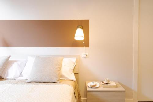 1 dormitorio con 1 cama con lámpara y mesa auxiliar en NEW! Milano - Flowers Home, en Cusano Milanino