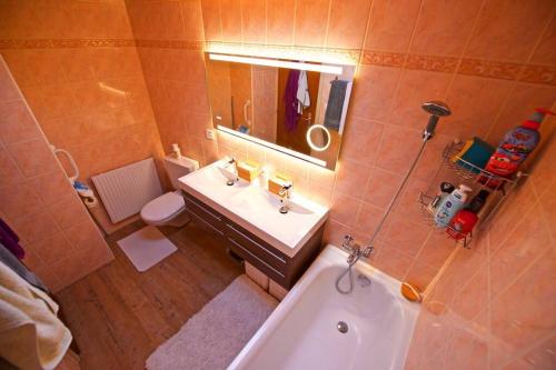 a bathroom with a tub and a sink and a toilet at Lovely house in a quiet place in Bôle