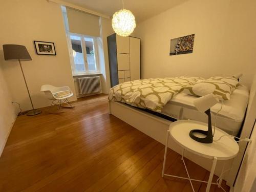 a bedroom with a bed and a table and a lamp at la meta appartamento vista lago con parcheggio in Minusio