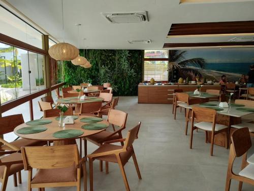 una sala da pranzo con tavoli e sedie e un ristorante di MANA BEACH EXPERIENCE by AFT Porto de Galinhas, Muro Alto a Porto De Galinhas