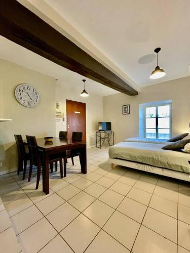 ein Schlafzimmer mit einem Bett, einem Schreibtisch und einer Uhr in der Unterkunft *Au centre de la ville haute G* ZEN LOC 6 in Provins