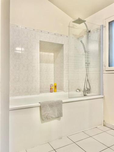 uma casa de banho branca com um chuveiro e uma banheira em *Au centre de la ville haute G* ZEN LOC 6 em Provins