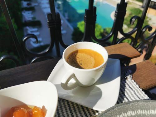a cup of coffee sitting on a plate on a table at Lily Beach - Apartment 408A in Sozopol
