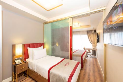 a hotel room with two beds and a tv at Ramada By Wyndham Istanbul Pera Taksim in Istanbul