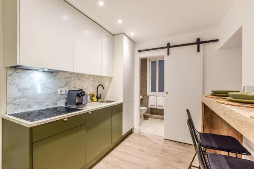 una cucina con armadi verdi e piano di lavoro di AmazINN Places Gran Via VII a Madrid