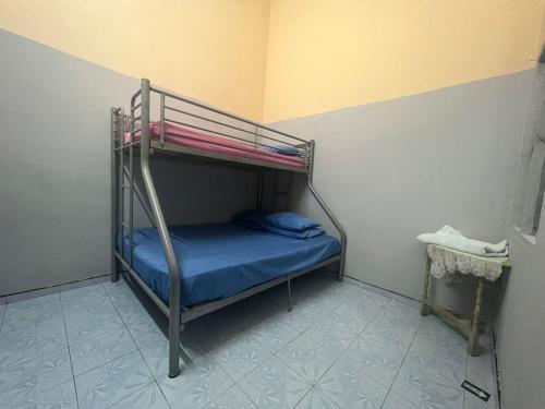 een stapelbed in een kamer met een blauw bed bij HOMESTAY NO.45 in Jitra