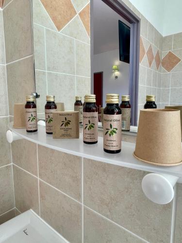 - une étagère dans une salle de bains avec des pots de miel dans l'établissement Auberge de Barret sur Meouge, à Barret-sur-Meouge