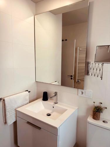 a white bathroom with a sink and a mirror at #PrettyPenthouseEstepona in Estepona