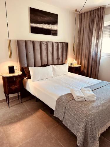 a bedroom with a large bed with two towels on it at #PrettyPenthouseEstepona in Estepona